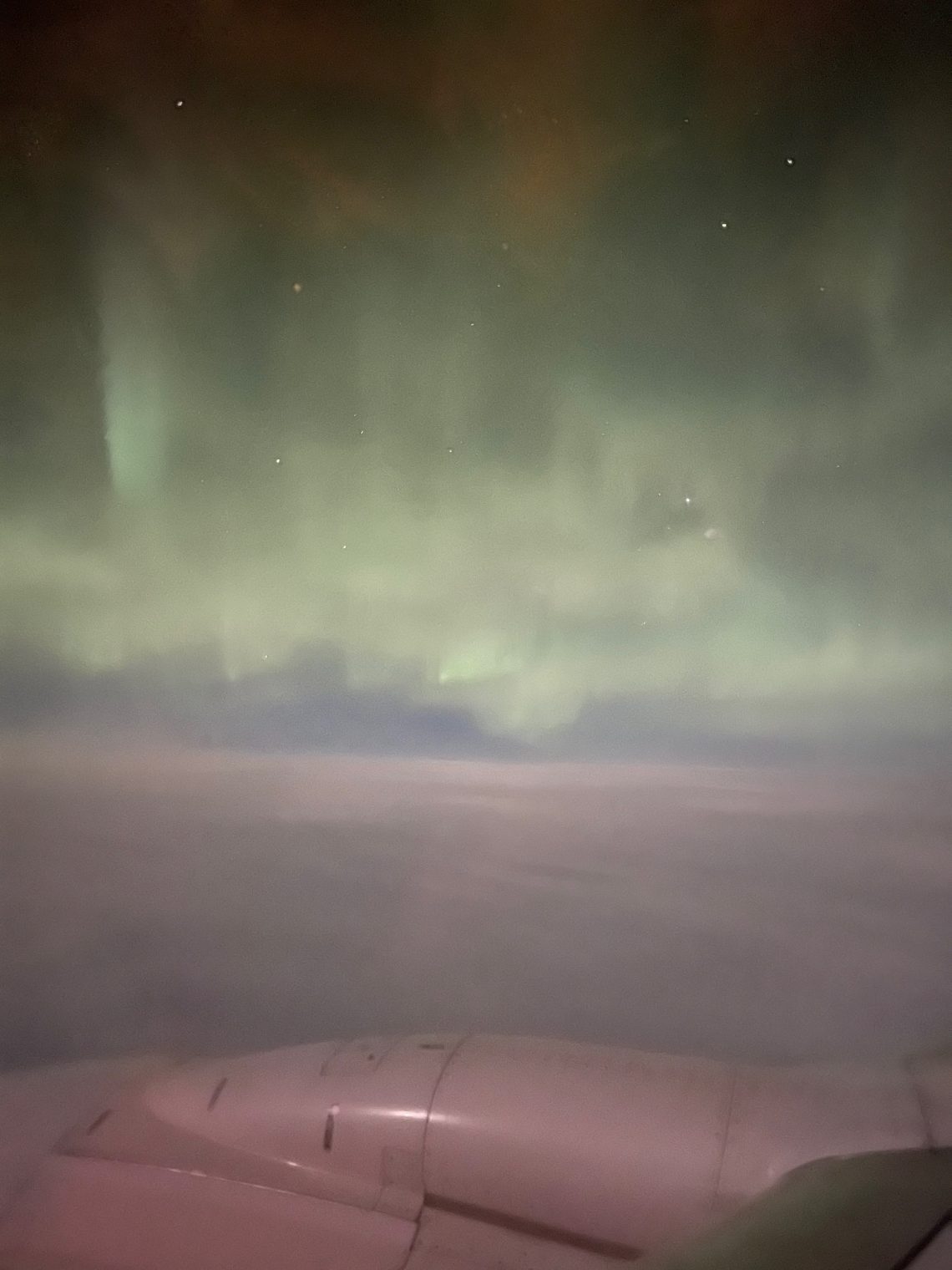 Green northern lights through the airplane window